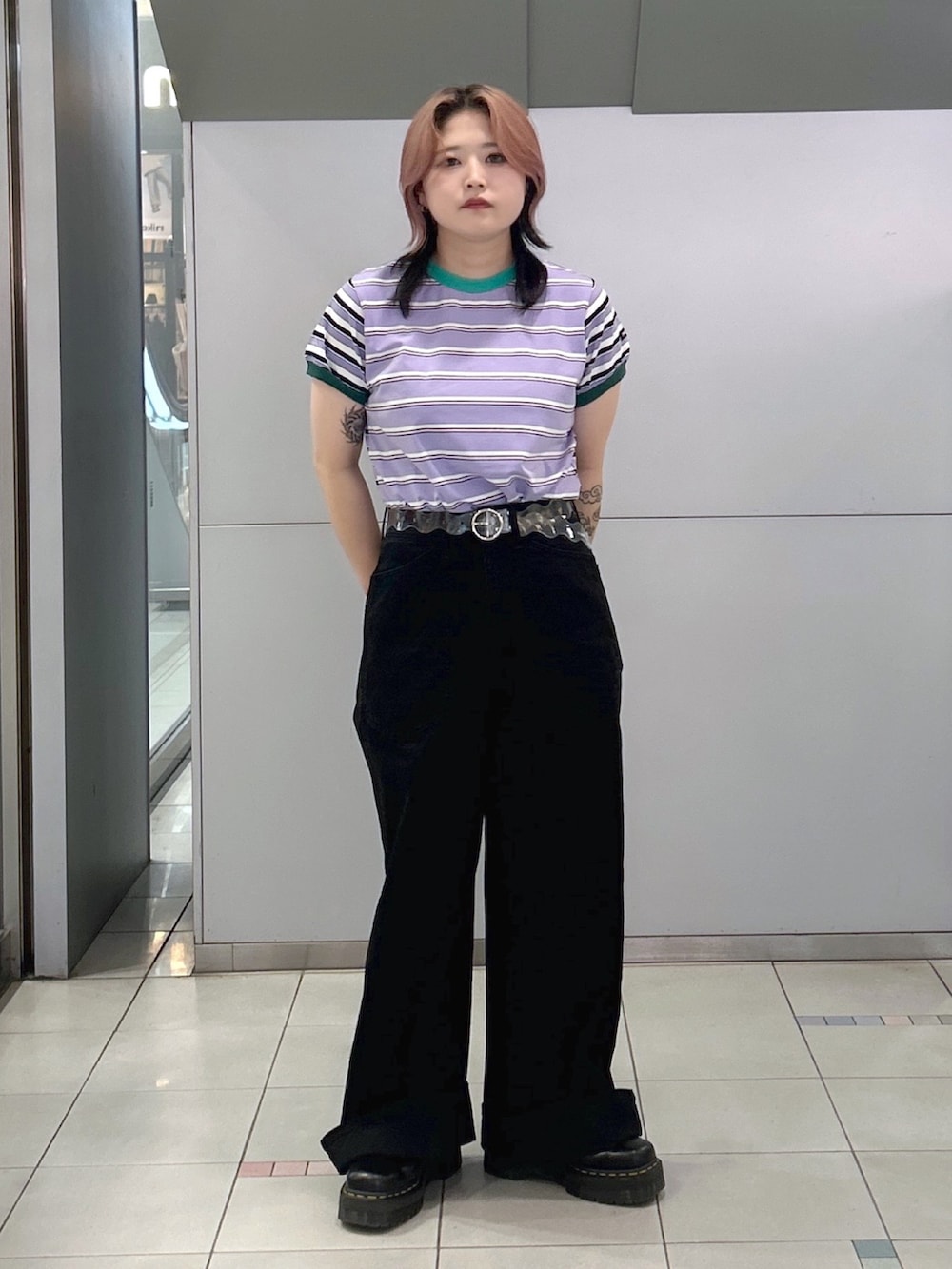 パープル系のTシャツ/カットソー、ブラック系のデニムパンツ、ブラック系のブーツを着用したレディースの夏コーディネートの2枚目の写真