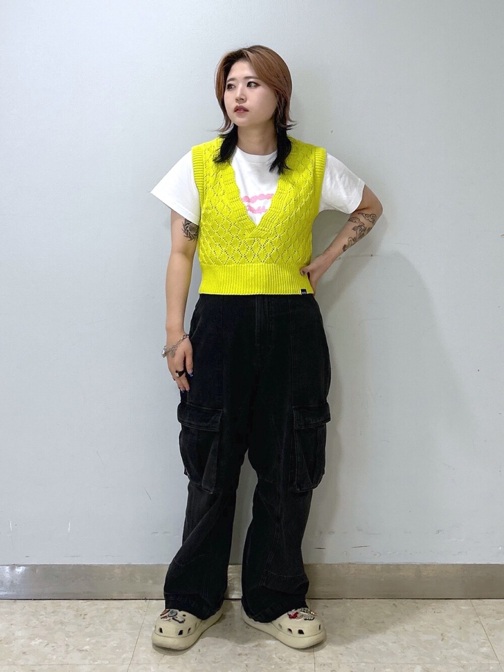 ホワイト系のTシャツ/カットソー、イエロー系のベスト、ブラック系のカーゴパンツを着用したレディースの夏コーディネートの2枚目の写真