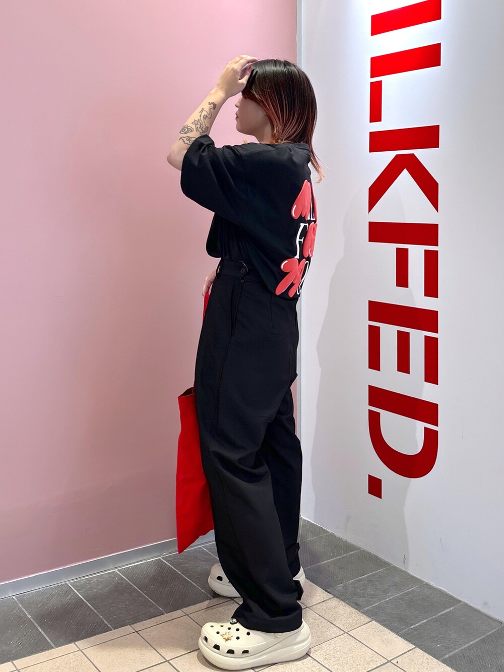 ブラック系のTシャツ/カットソー、レッド系のトートバッグ、ブラック系のその他パンツを着用したレディースの夏コーディネートの3枚目の写真