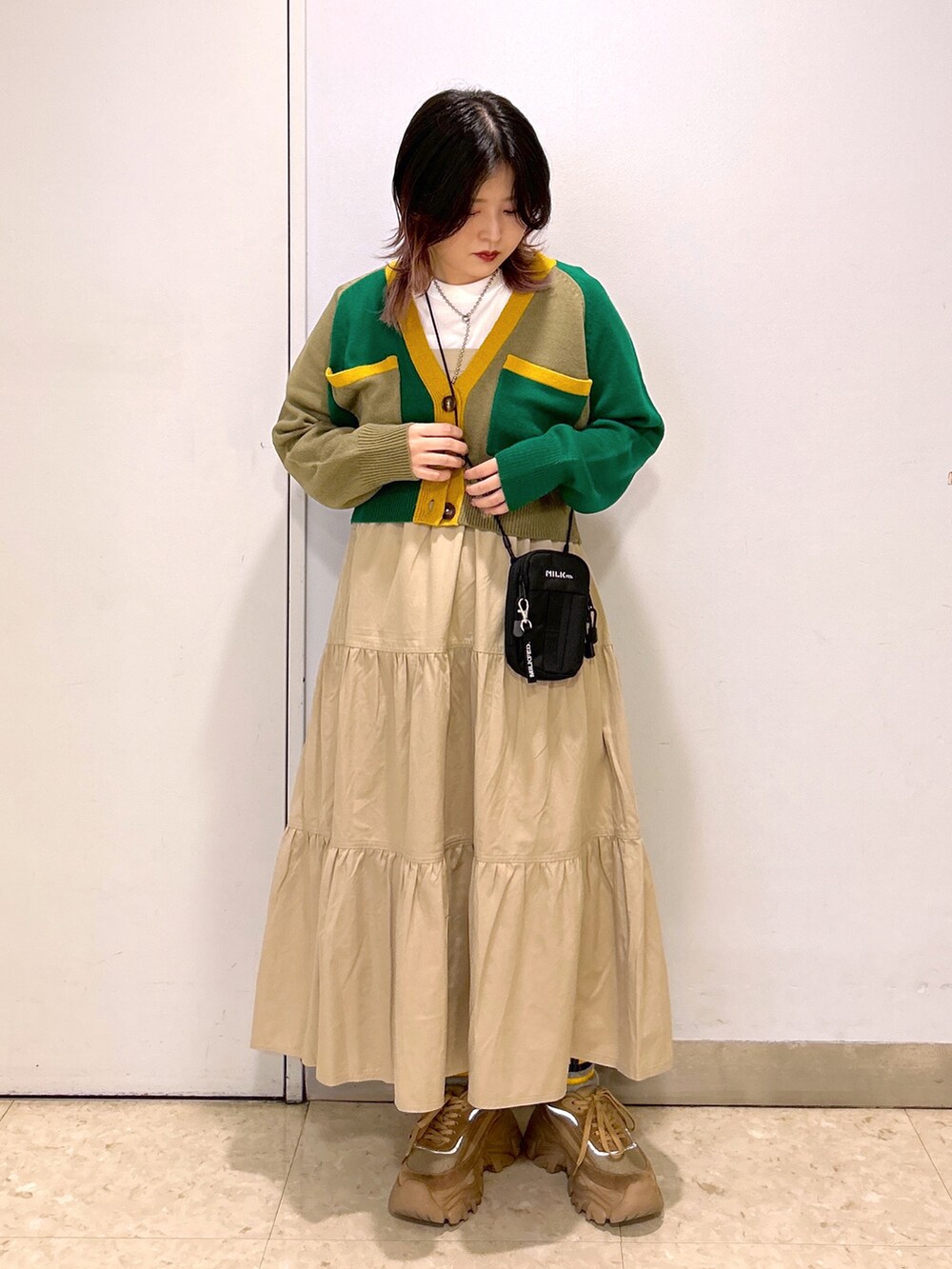 ベージュ系のカーディガン/ボレロ、ブラック系のショルダーバッグ、ベージュ系のワンピースを着用したレディースの夏コーディネートの2枚目の写真