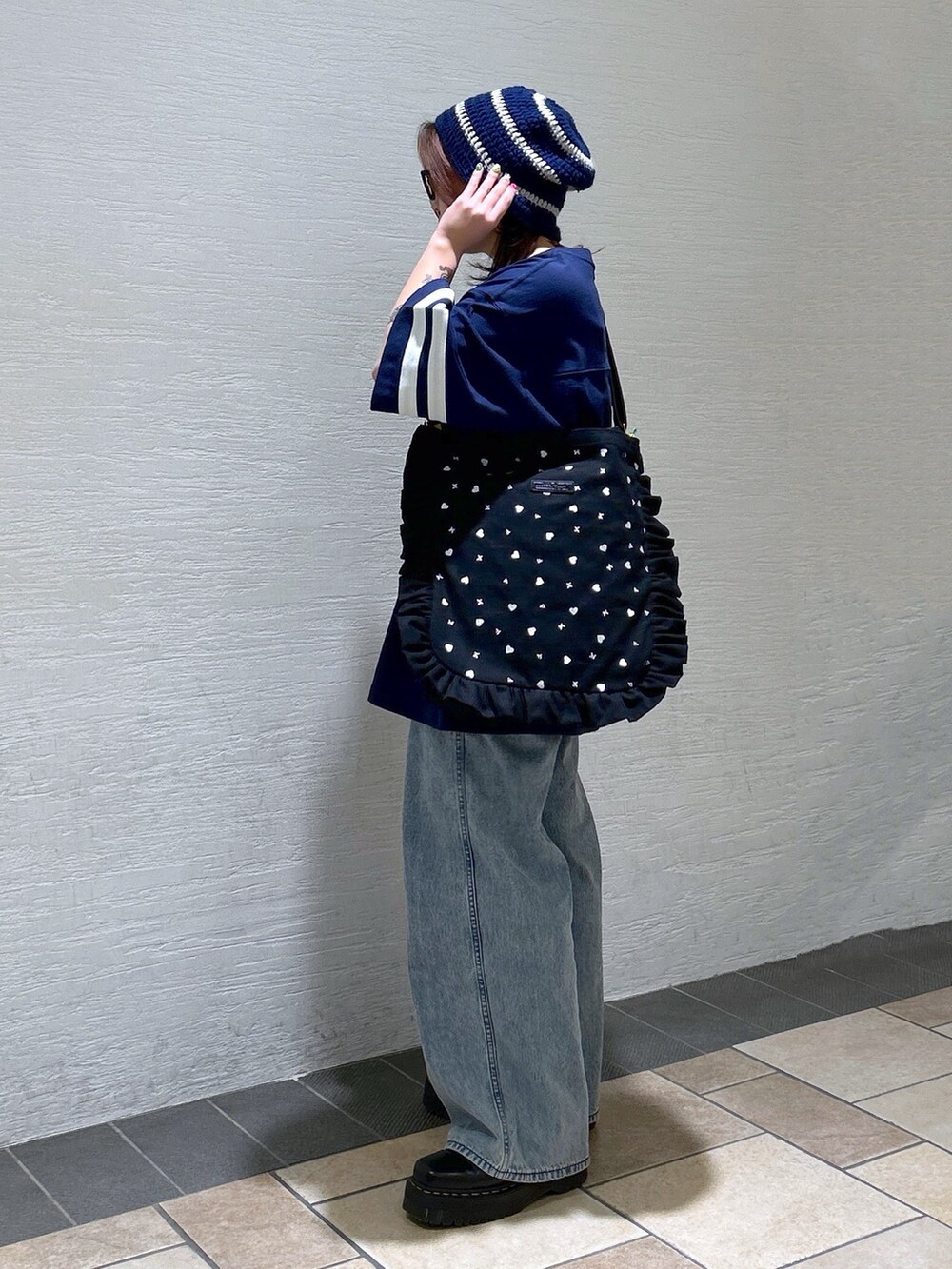 ブルー系のTシャツ/カットソー、ブルー系のデニムパンツ、ブラック系のブーツを着用したレディースの冬コーディネートの4枚目の写真