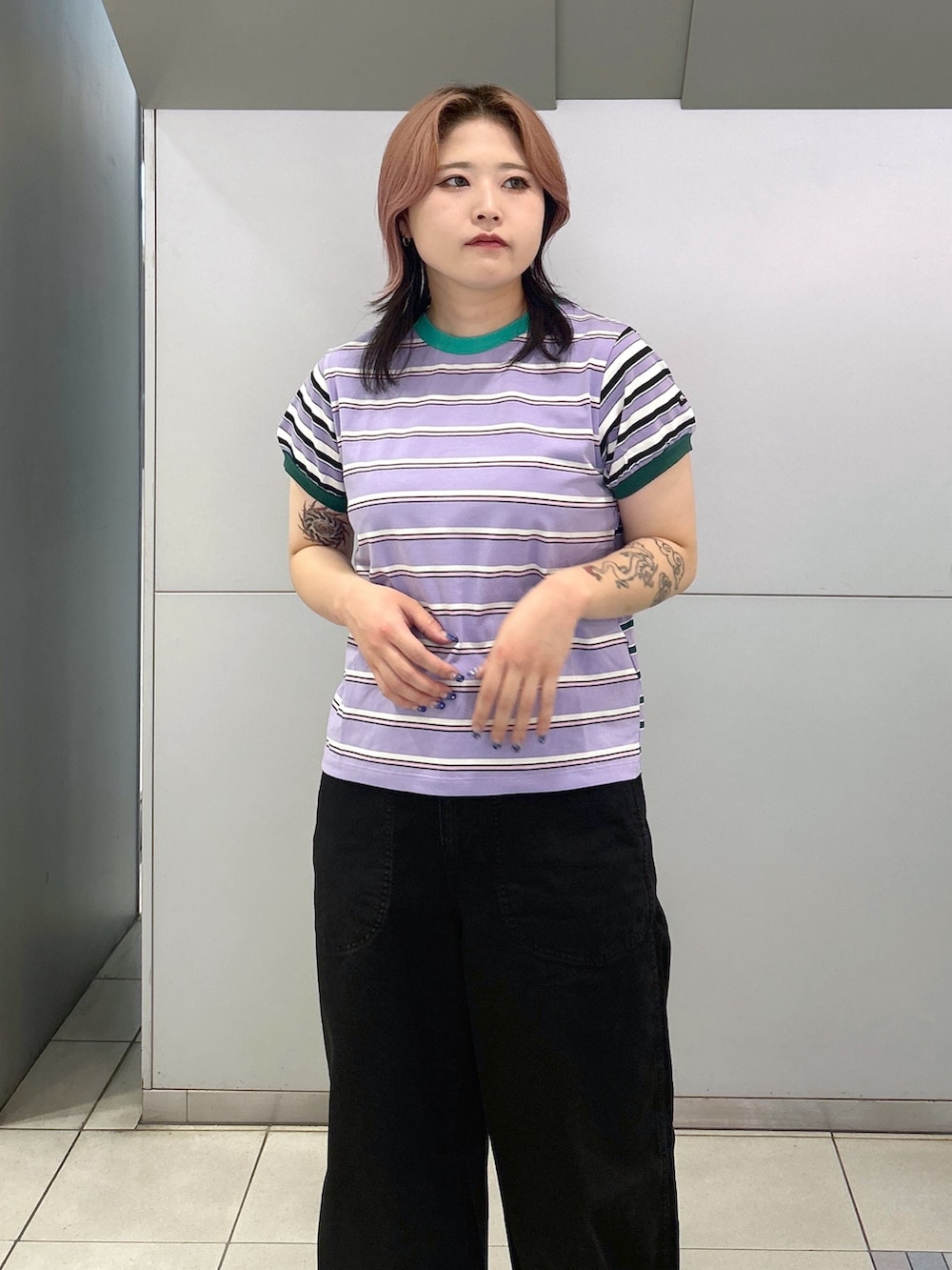 パープル系のTシャツ/カットソー、ブラック系のデニムパンツ、ブラック系のブーツを着用したレディースの夏コーディネートの5枚目の写真