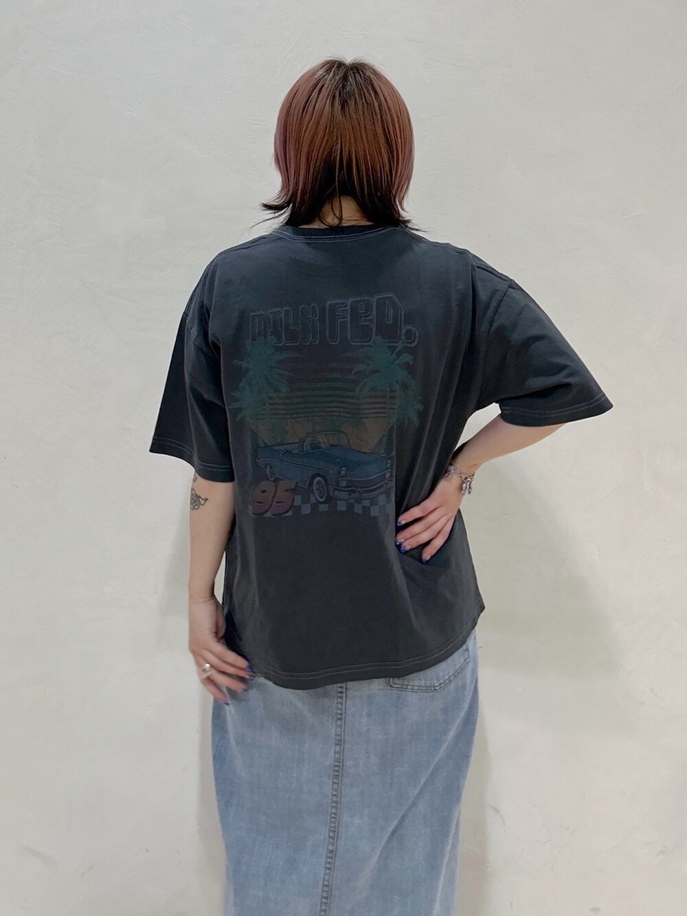 グレー系のTシャツ/カットソー、グリーン系のショルダーバッグ、ブルー系のデニムスカートを着用したレディースの夏コーディネートの5枚目の写真