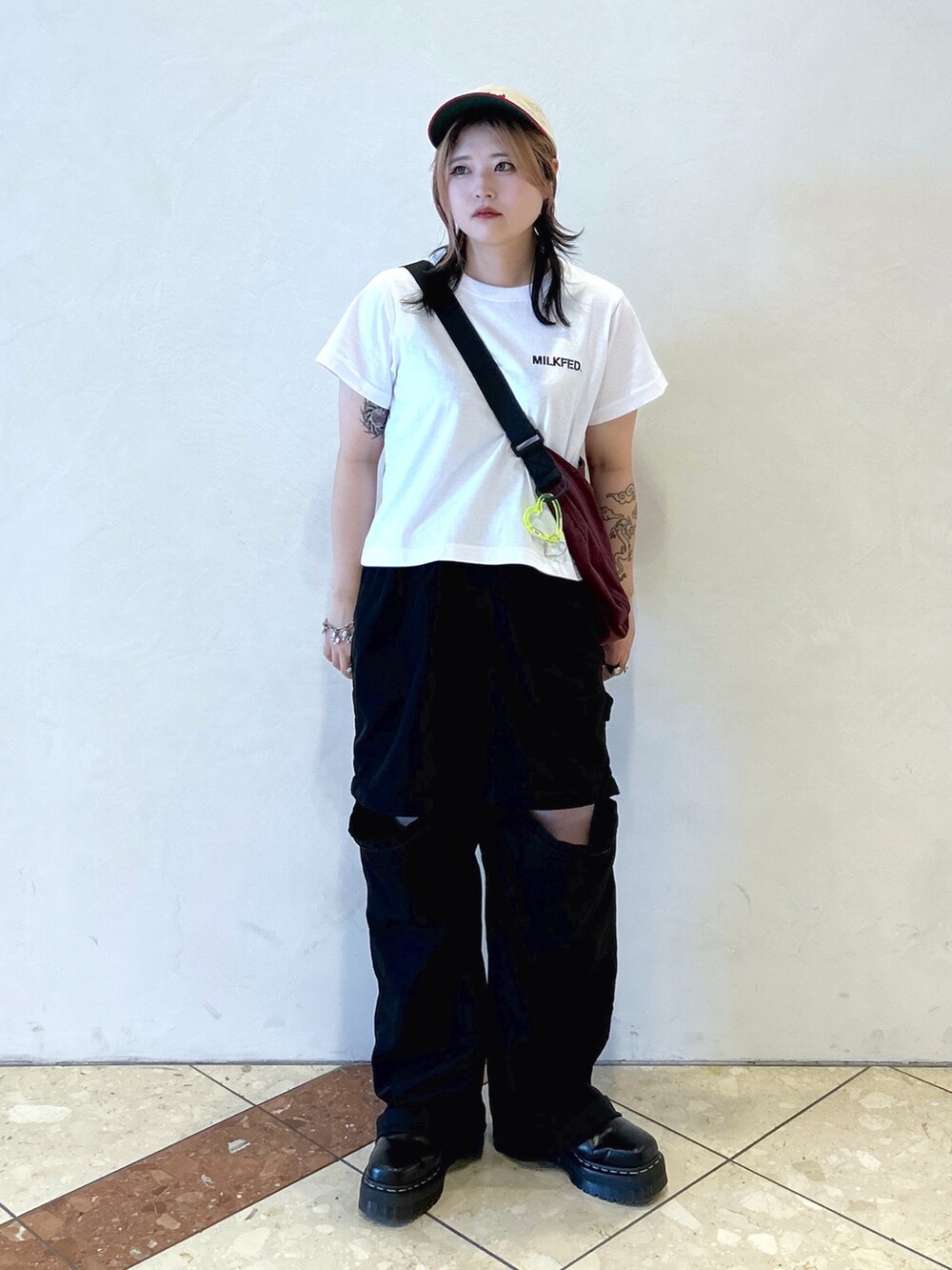 ブラック系のその他パンツ、レッド系のショルダーバッグ、ホワイト系のTシャツ/カットソーを着用したレディースの夏コーディネートの2枚目の写真