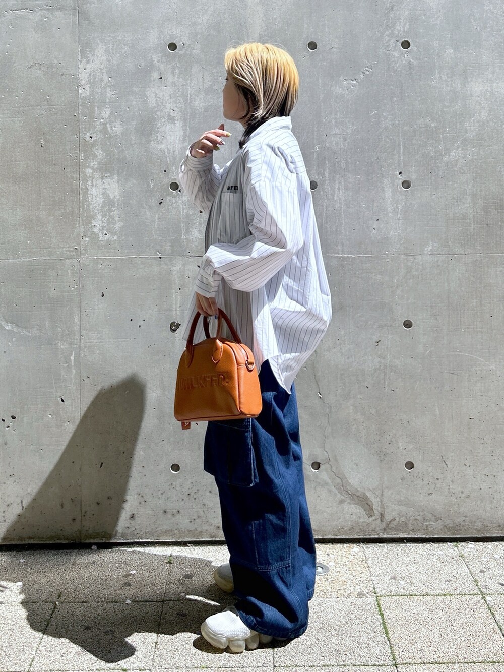 ブルー系のTシャツ/カットソー、ブラウン系のボストンバッグ、ブルー系のカーゴパンツを着用したレディースの春コーディネートの3枚目の写真