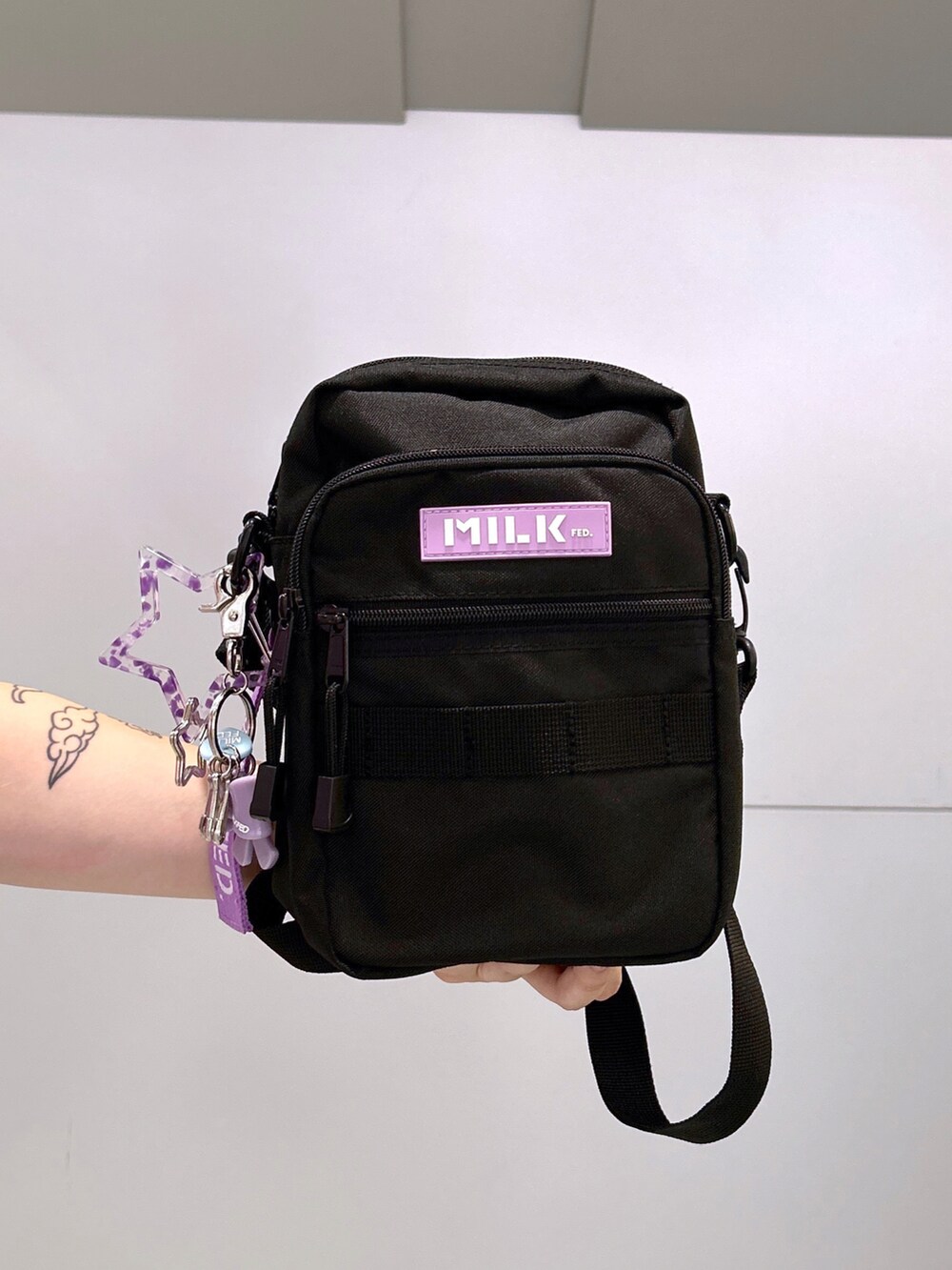 パープル系のTシャツ/カットソー、パープル系のショルダーバッグ、ホワイト系のスカートを着用したレディースの秋コーディネートの4枚目の写真