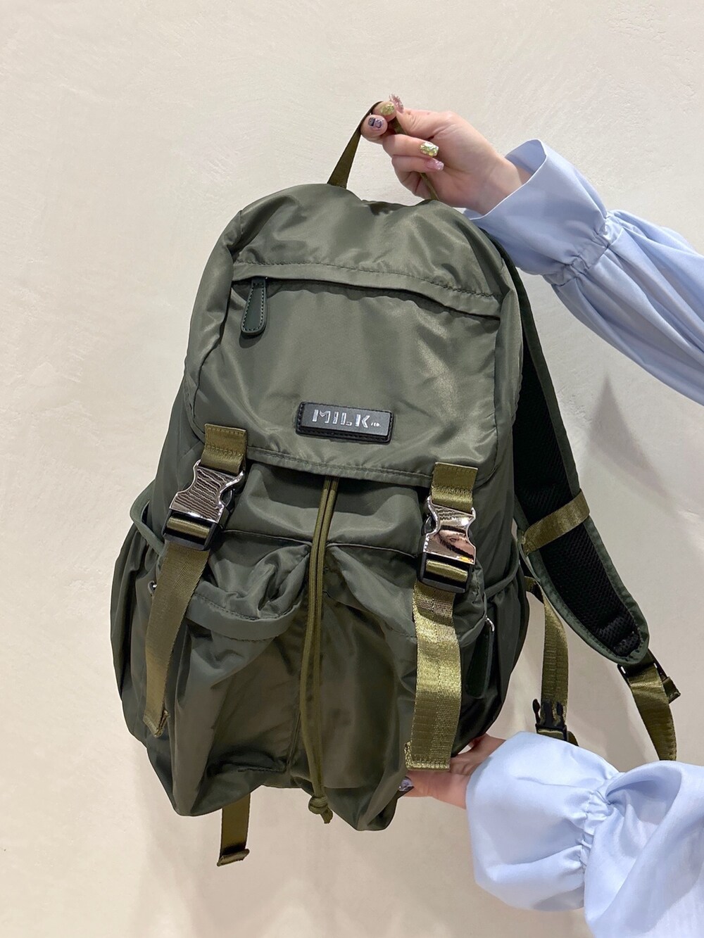 ブルー系のシャツ/ブラウス、グリーン系のバックパック/リュック、ブラック系のデニムパンツを着用したレディースの春コーディネートの8枚目の写真