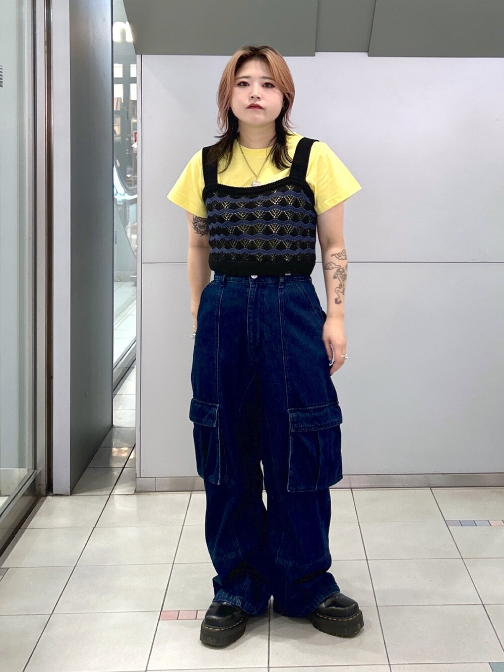 イエロー系のTシャツ/カットソー、ブラック系のキャミソール、ブラック系のブーツを着用したレディースの夏コーディネートの3枚目の写真