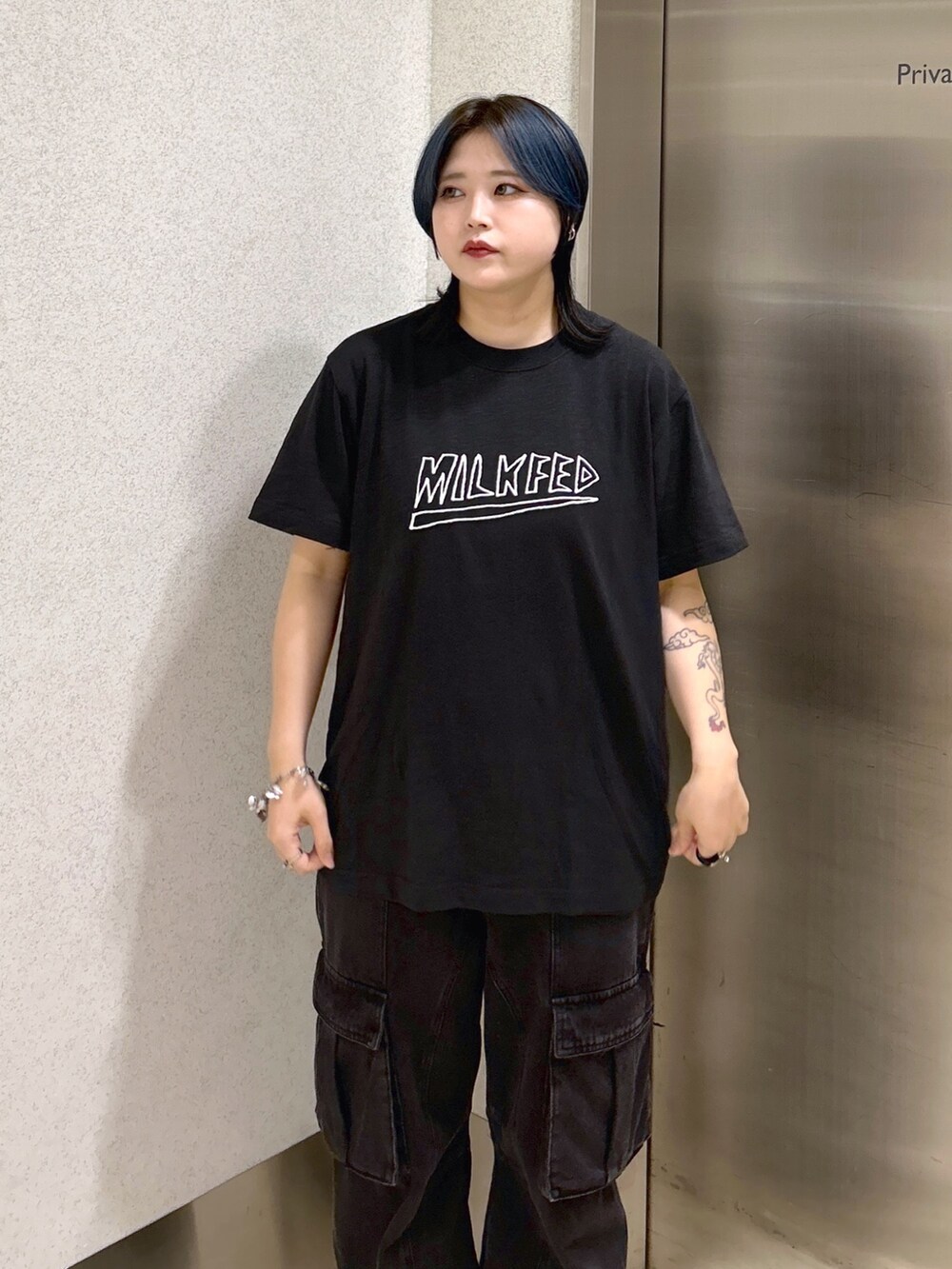 ブラック系のTシャツ/カットソー、ブラック系のカーゴパンツ、ベージュ系のショルダーバッグを着用したレディースの夏コーディネートの6枚目の写真
