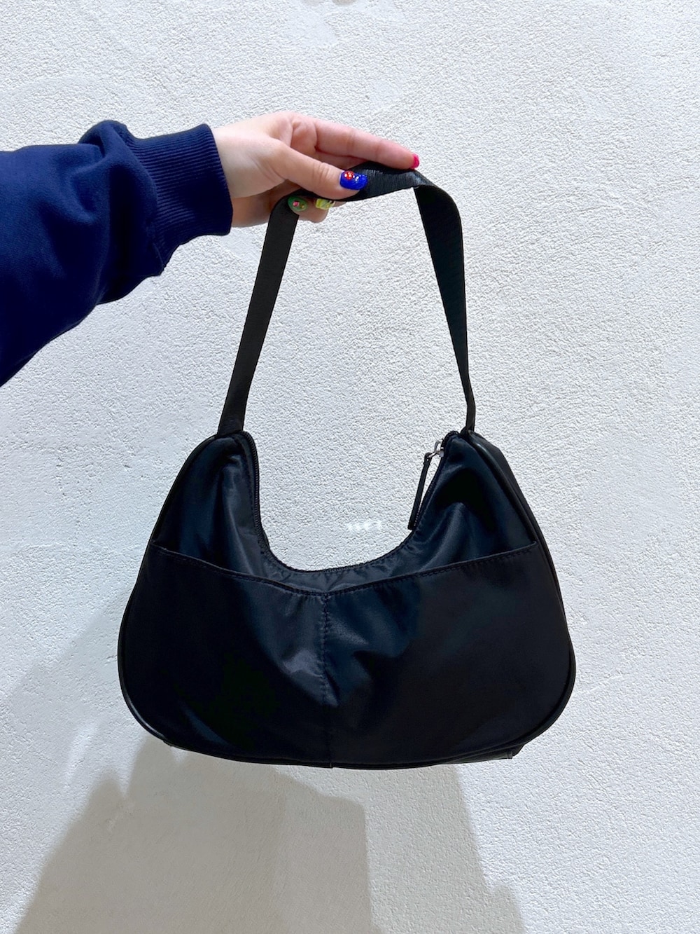 ブルー系のパーカー、イエロー系のその他パンツ、ブラック系のハンドバッグを着用したレディースの冬コーディネートの7枚目の写真