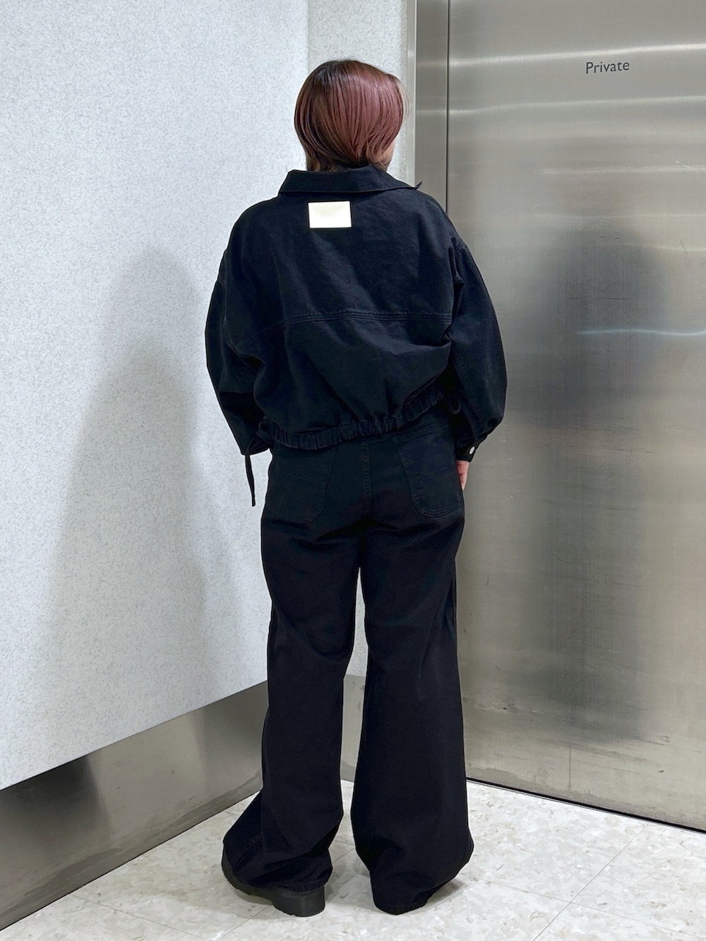 ブラック系のデニムジャケット、ブラック系のデニムパンツ、ブラック系のブーツを着用したレディースの冬コーディネートの4枚目の写真