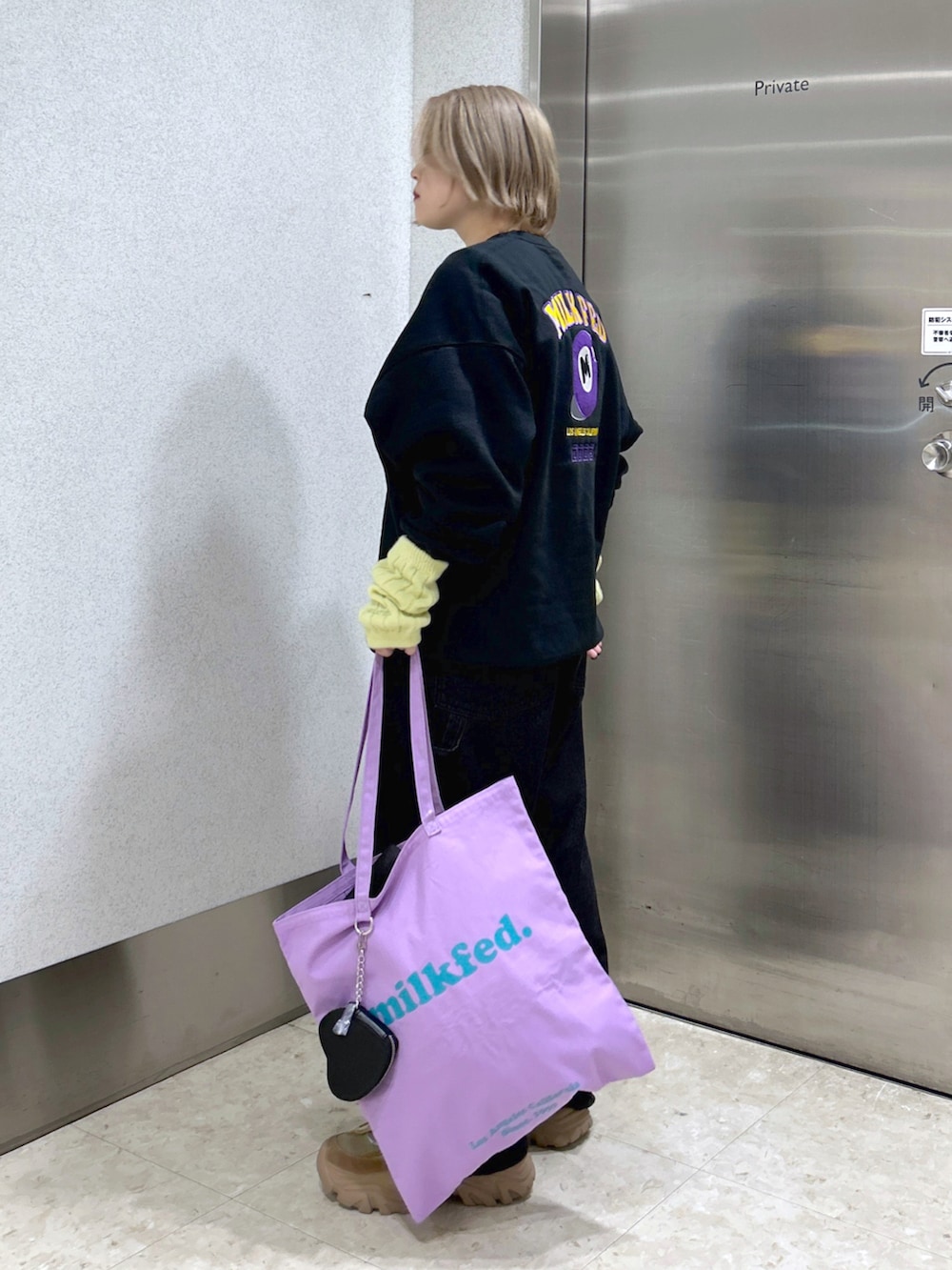 ブラック系のスウェット、ブラック系のサロペット/オーバーオール、ベージュ系のスニーカーを着用したレディースの秋コーディネートの2枚目の写真