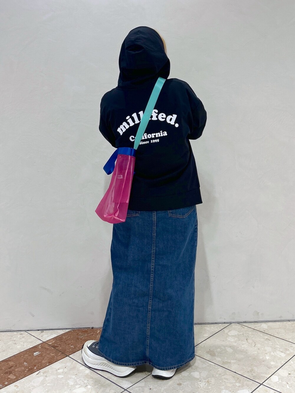 ブルー系のデニムスカート、ピンク系のショルダーバッグ、ホワイト系のTシャツ/カットソーを着用したレディースの春コーディネートの5枚目の写真