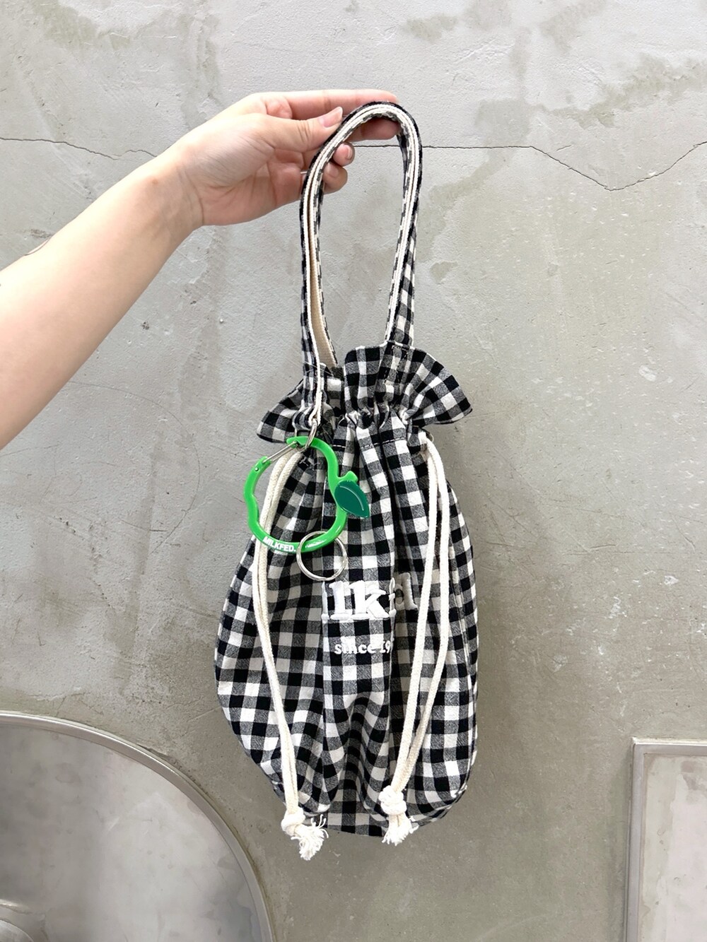 ブルー系のタンクトップ、ホワイト系のカーディガン/ボレロ、ベージュ系のサンダルを着用したレディースの夏コーディネートの7枚目の写真