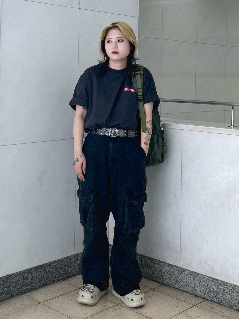 グレー系のTシャツ/カットソー、グリーン系のバックパック/リュック、ブラック系のカーゴパンツを着用したレディースの春コーディネートの3枚目の写真