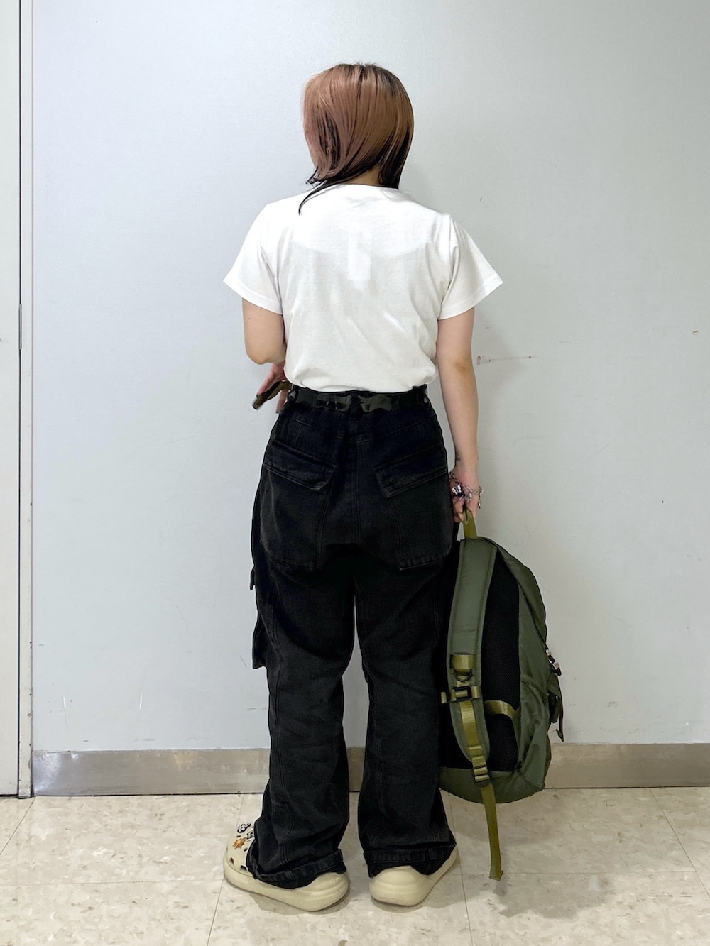 ベージュ系のサンダル、グリーン系のバックパック/リュック、ホワイト系のTシャツ/カットソーを着用したレディースの夏コーディネートの4枚目の写真