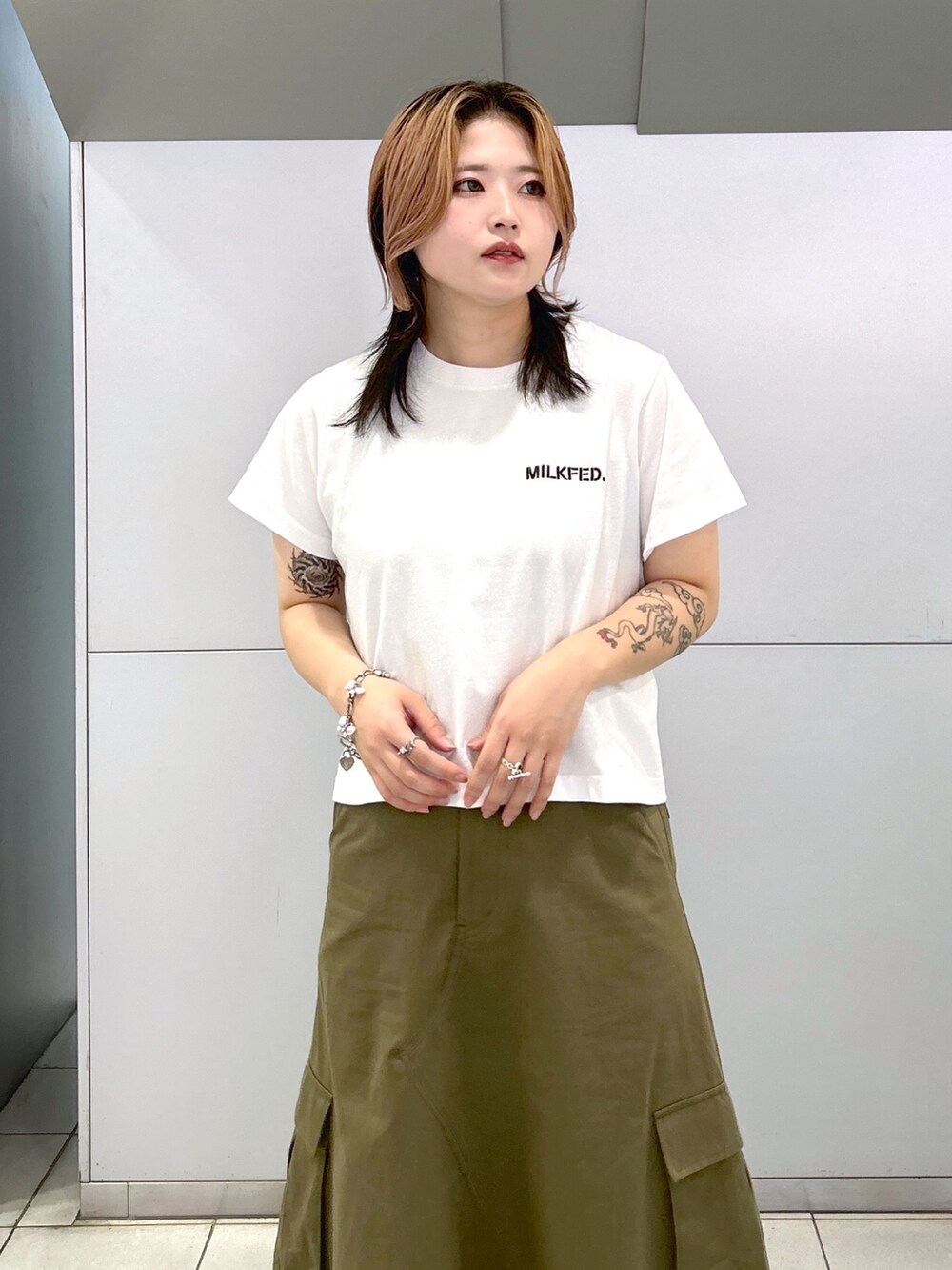 ベージュ系のサンダル、ベージュ系のショルダーバッグ、グリーン系のスカートを着用したレディースの夏コーディネートの3枚目の写真