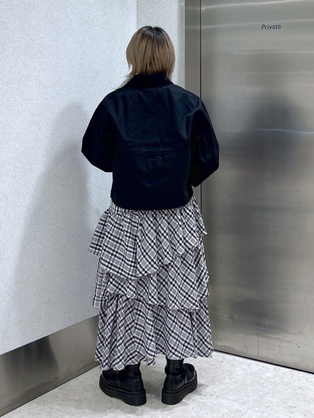 ブラック系のカバーオール、ブルー系のTシャツ/カットソー、ブラック系のスカートを着用したレディースの冬コーディネートの3枚目の写真