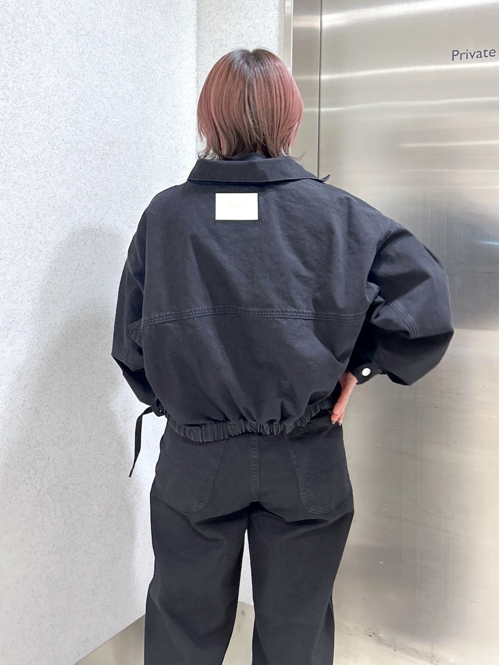 ブラック系のデニムジャケット、ブラック系のデニムパンツ、ブラック系のブーツを着用したレディースの冬コーディネートの6枚目の写真