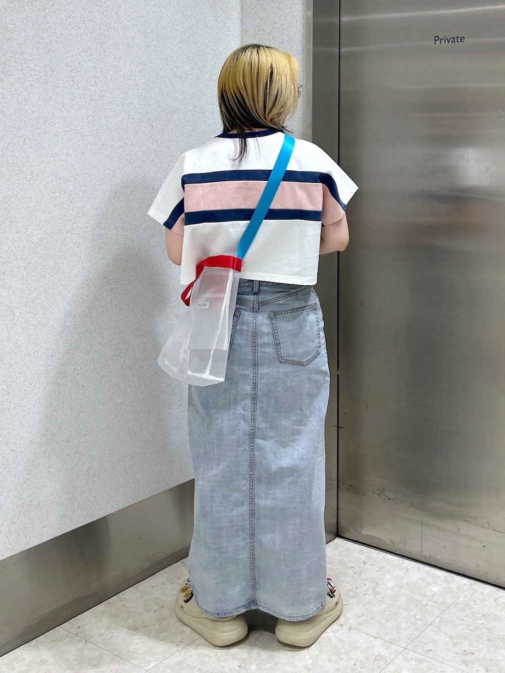 ホワイト系のTシャツ/カットソー、ブルー系のデニムスカート、ホワイト系のショルダーバッグを着用したレディースの春コーディネートの3枚目の写真