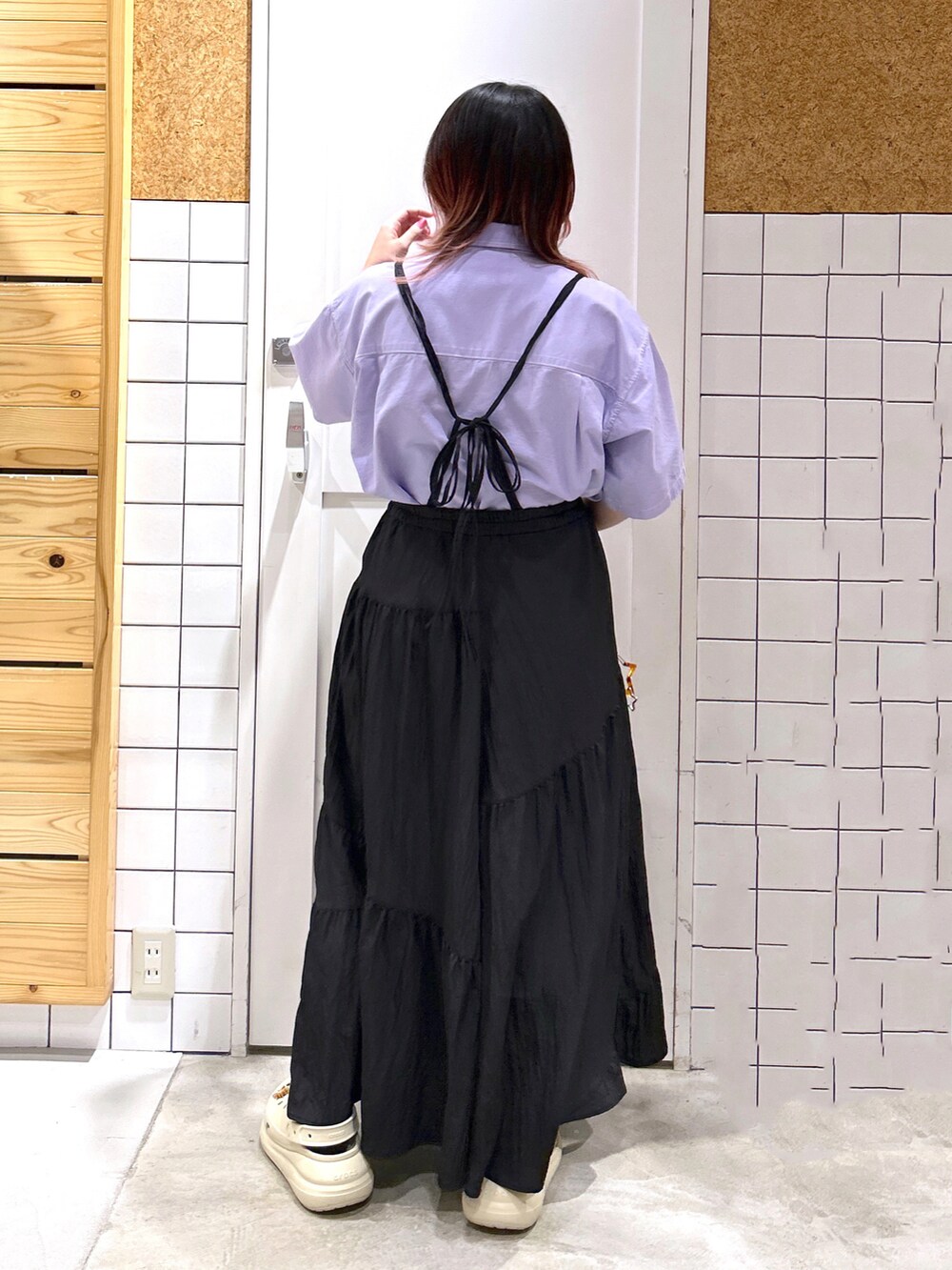 パープル系のシャツ/ブラウス、ブラック系のスカート、ブラウン系のボストンバッグを着用したレディースの夏コーディネートの2枚目の写真