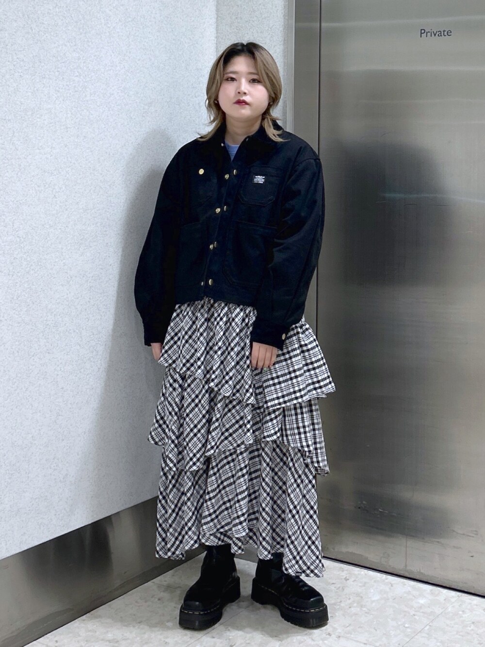 ブラック系のカバーオール、ブルー系のTシャツ/カットソー、ブラック系のスカートを着用したレディースの冬コーディネートの2枚目の写真