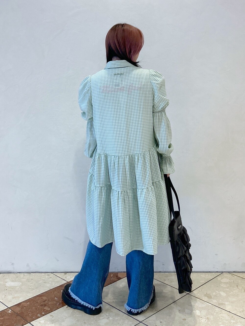 グリーン系のワンピース、ブルー系のデニムパンツ、ブラック系のトートバッグを着用したレディースの夏コーディネートの4枚目の写真