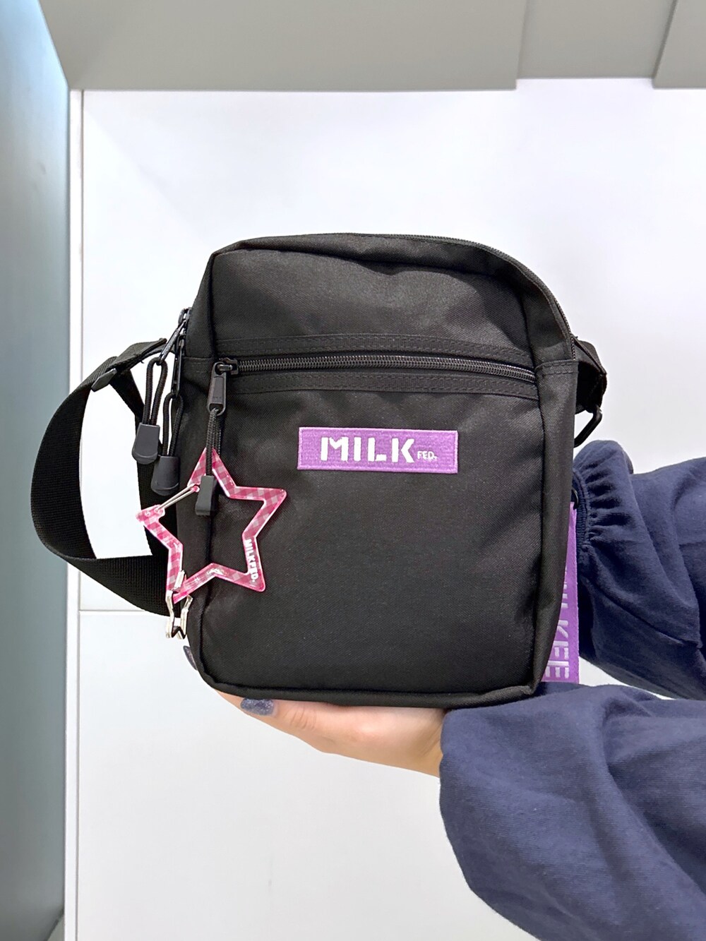 パープル系のベスト、ホワイト系のTシャツ/カットソー、パープル系のショルダーバッグを着用したレディースの秋コーディネートの4枚目の写真