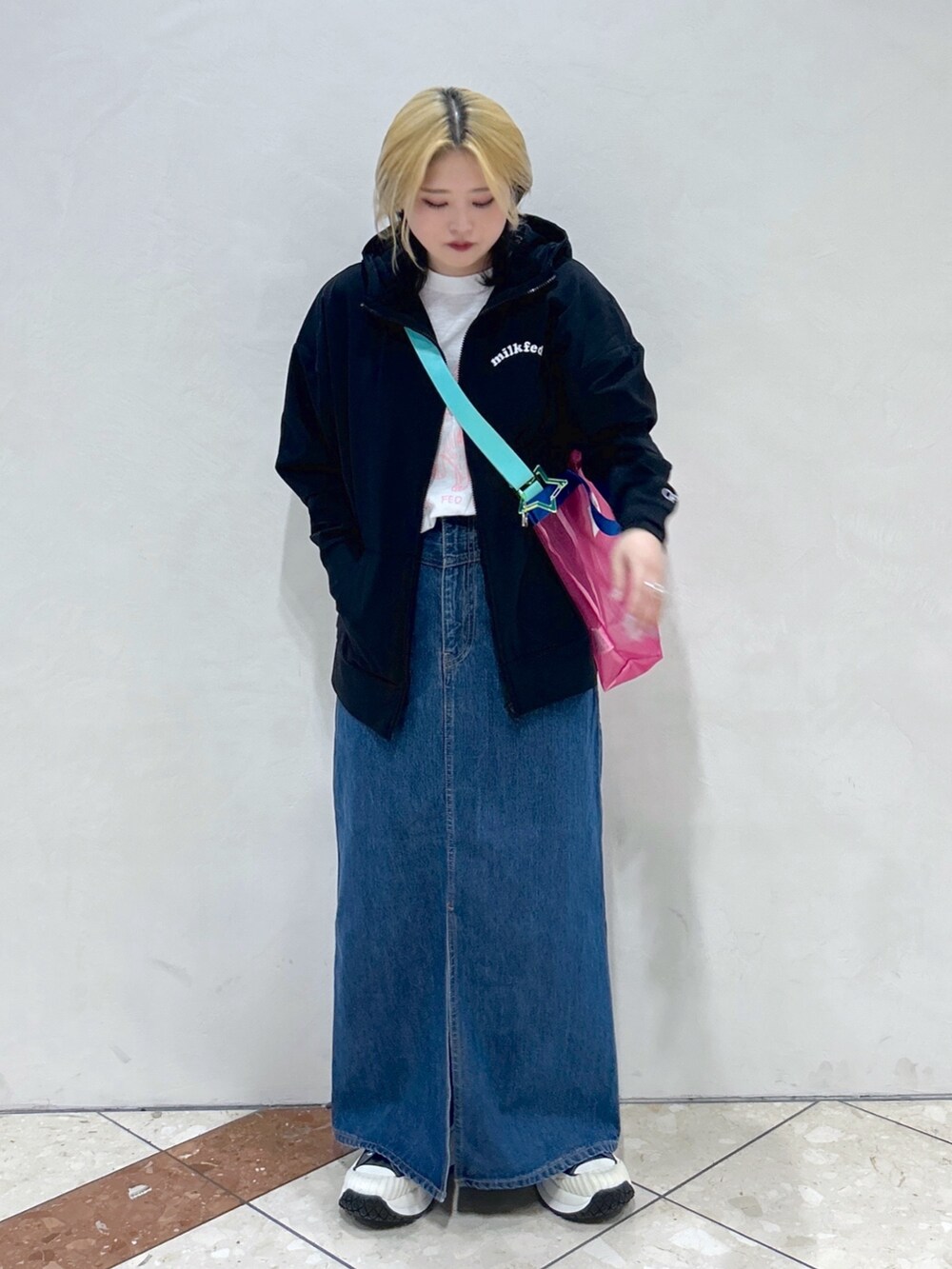 ブルー系のデニムスカート、ピンク系のショルダーバッグ、ホワイト系のTシャツ/カットソーを着用したレディースの春コーディネートの3枚目の写真