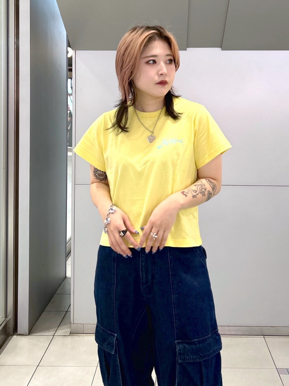 イエロー系のTシャツ/カットソー、ブラック系のキャミソール、ブラック系のブーツを着用したレディースの夏コーディネートの9枚目の写真