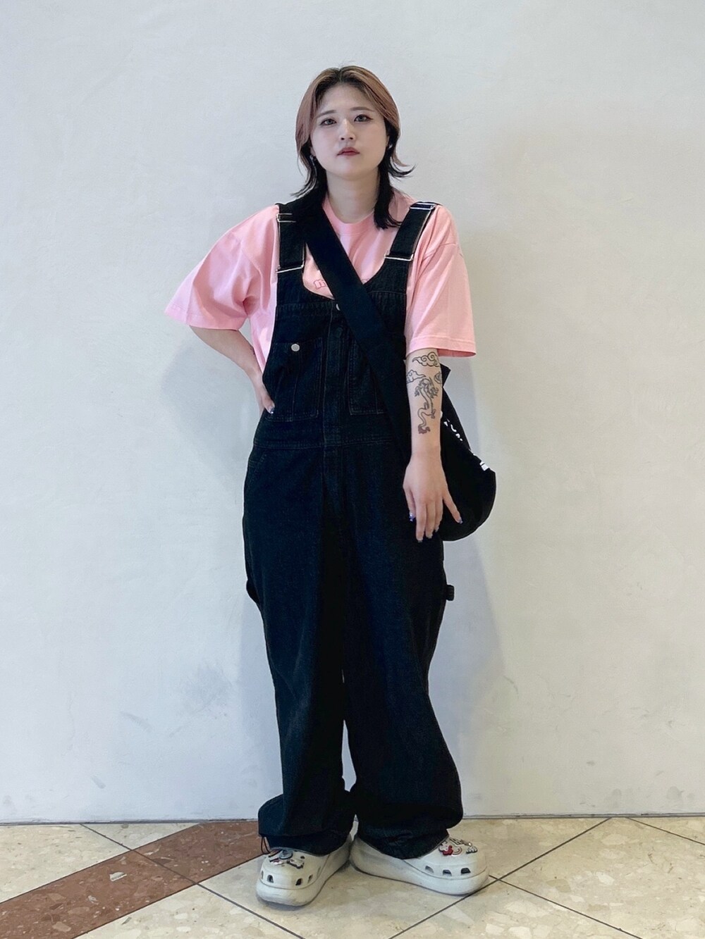 ピンク系のTシャツ/カットソー、ブラック系のショルダーバッグ、ブラック系のサロペット/オーバーオールを着用したレディースの夏コーディネートの2枚目の写真