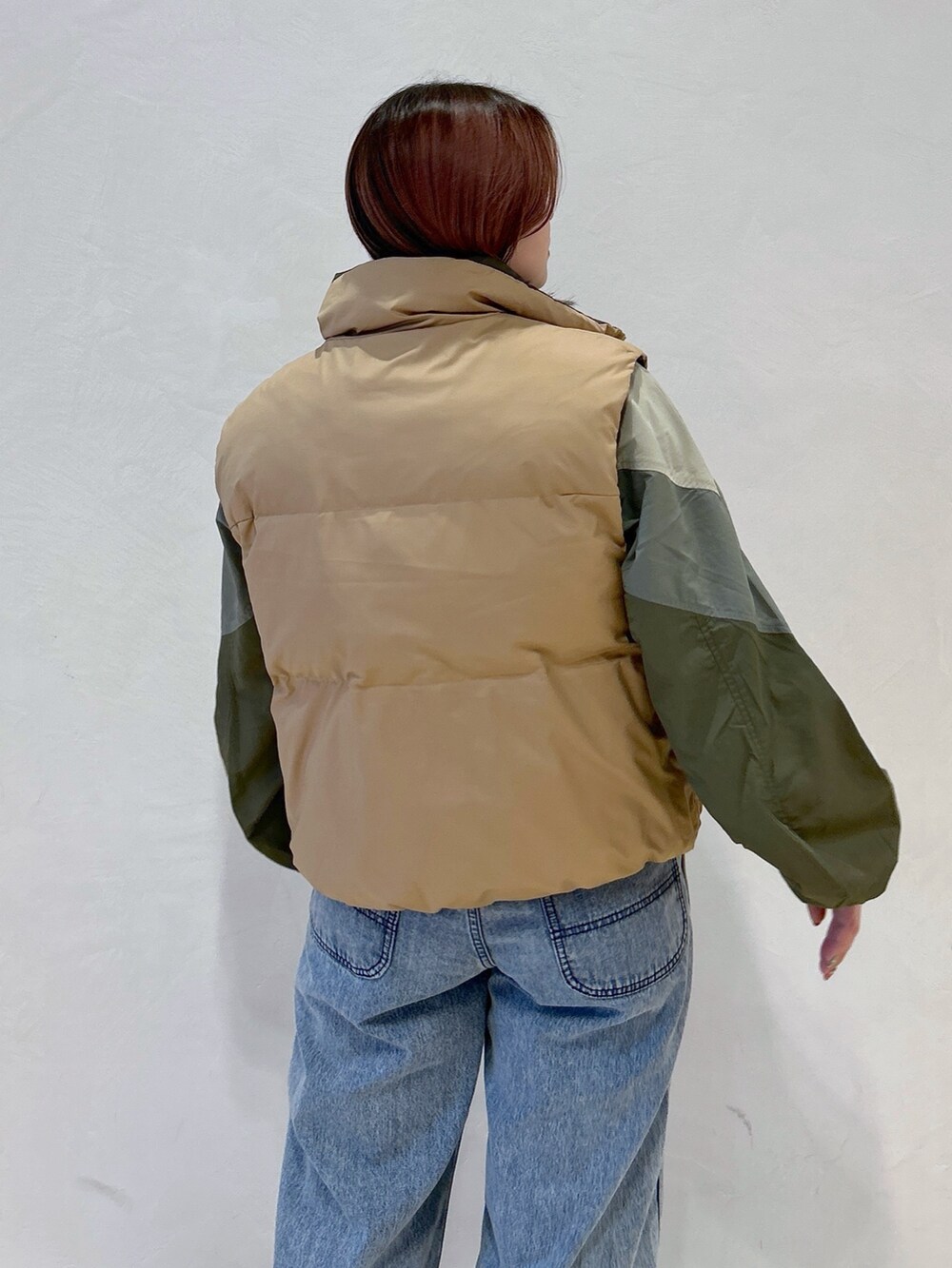 ブルー系のデニムパンツ、グリーン系のハンドバッグ、ブラック系のブーツを着用したレディースの冬コーディネートの7枚目の写真