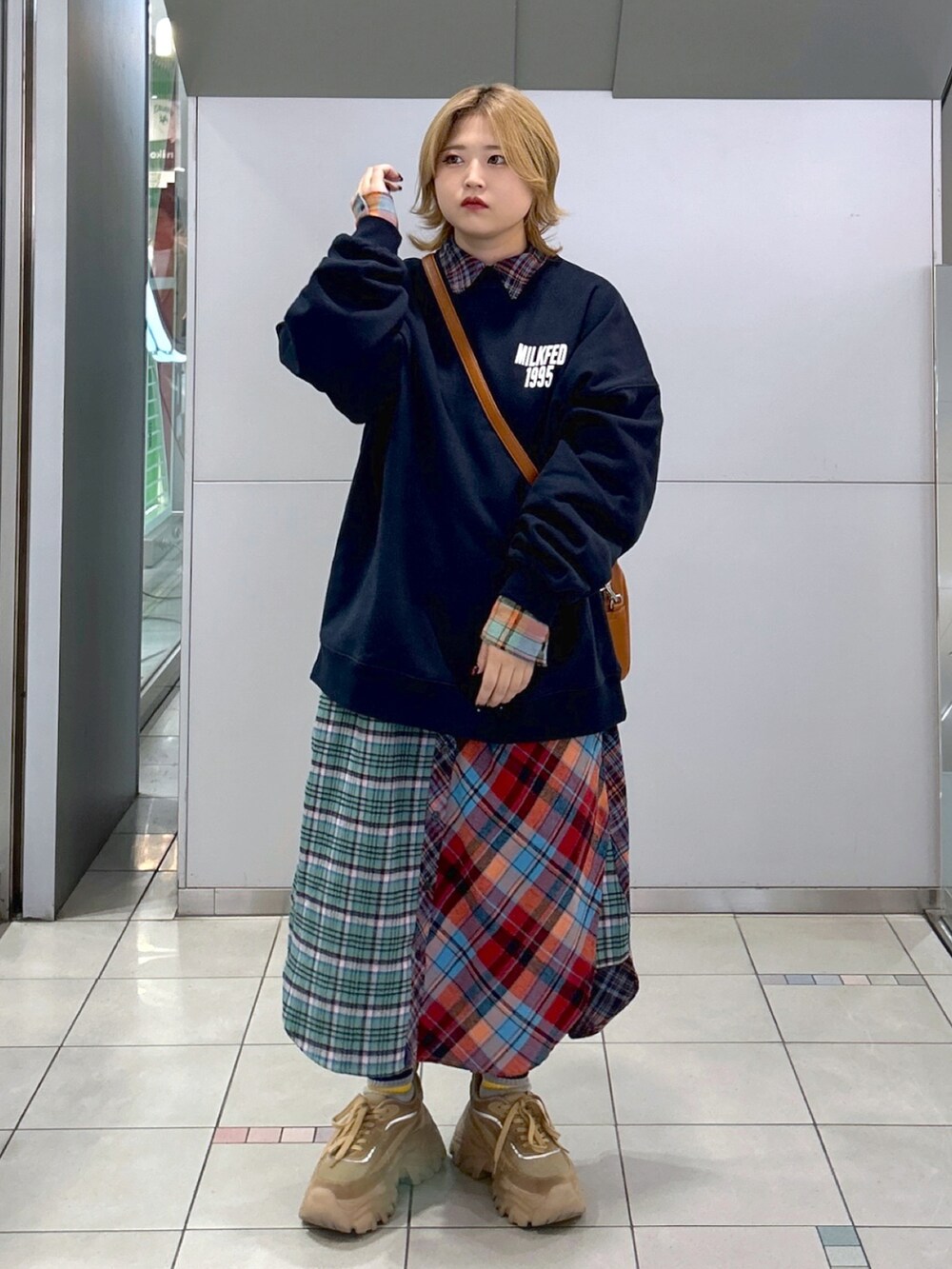 ブルー系のスウェット、ブラウン系のボストンバッグ、グリーン系のシャツワンピースを着用したレディースの秋コーディネートの2枚目の写真