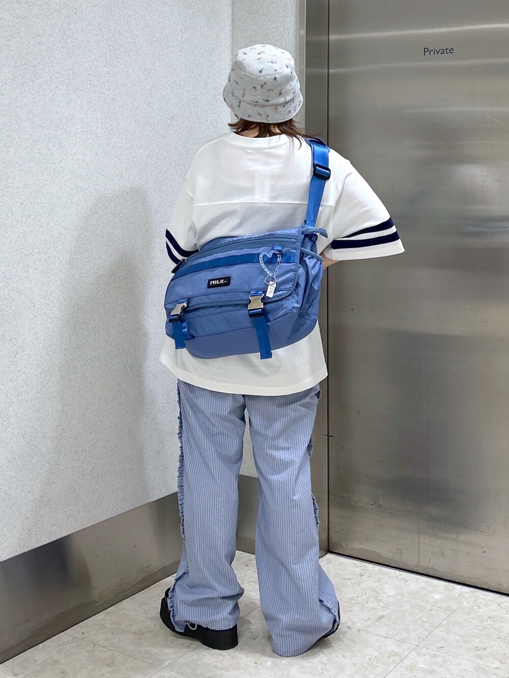 ブルー系のメッセンジャーバッグ、ホワイト系のTシャツ/カットソー、ブルー系のその他パンツを着用したレディースの春コーディネートの3枚目の写真