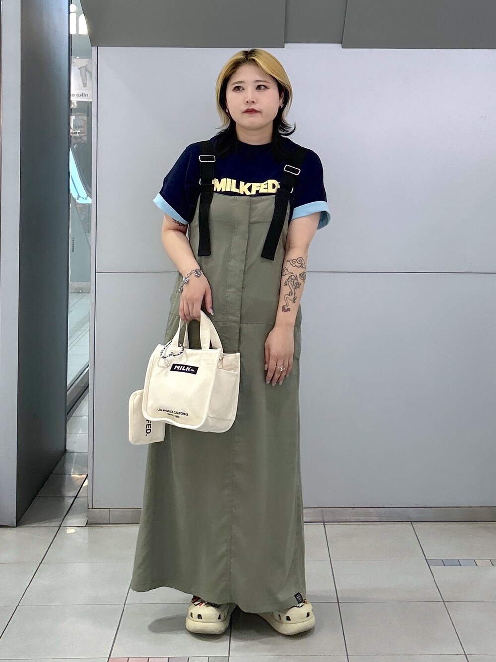 ブルー系のTシャツ/カットソー、グリーン系のワンピース、ホワイト系のショルダーバッグを着用したレディースの春コーディネートの3枚目の写真