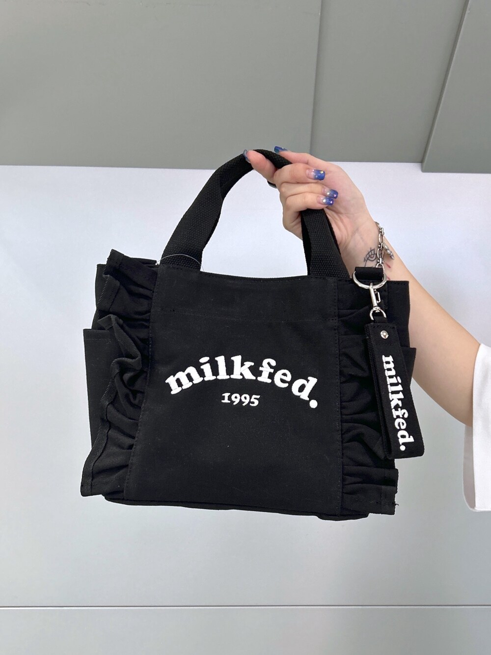 ホワイト系のTシャツ/カットソー、ブラック系のスカート、ベージュ系のサンダルを着用したレディースの夏コーディネートの5枚目の写真