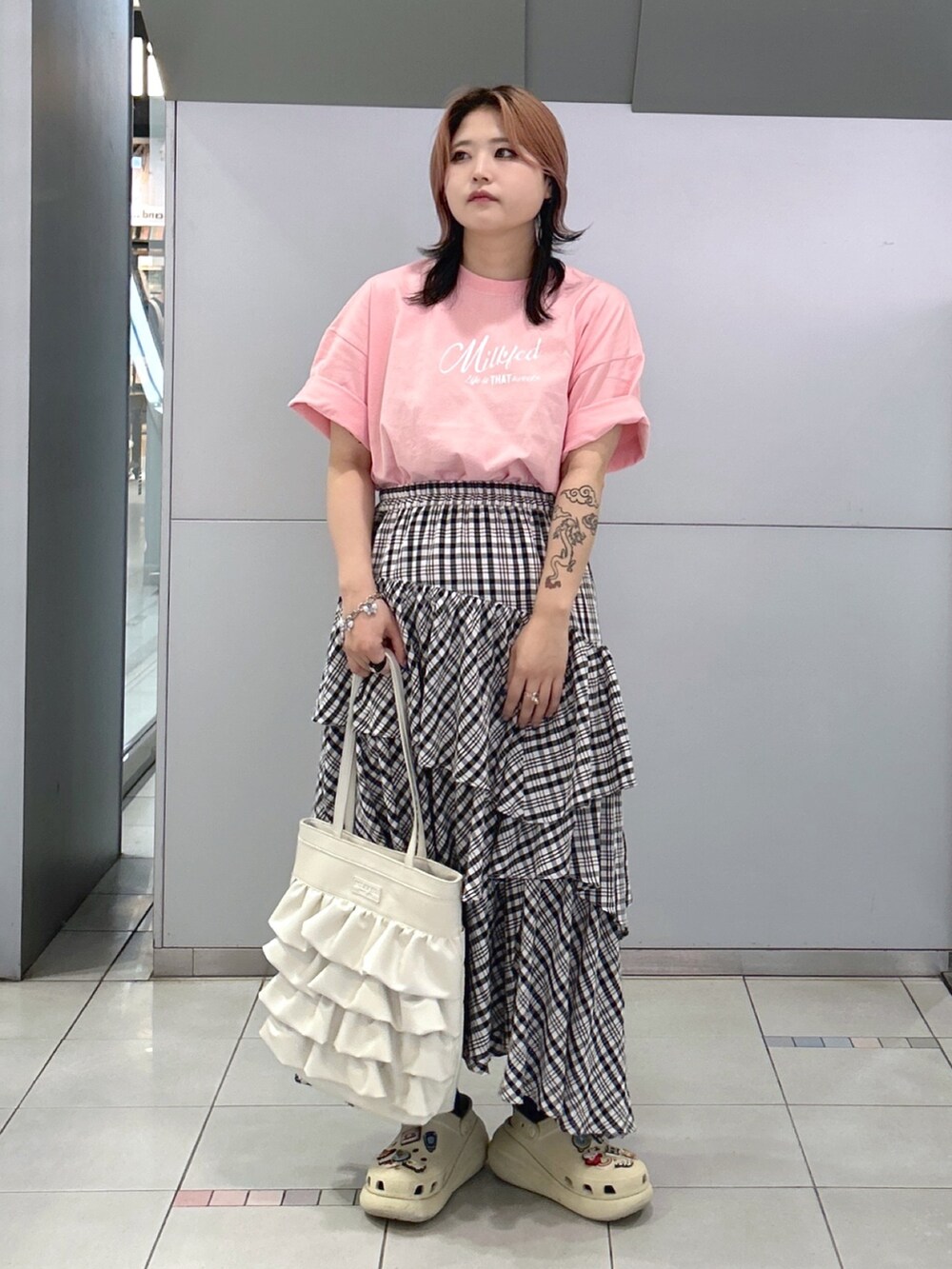 ピンク系のTシャツ/カットソー、ブラック系のスカート、ホワイト系のトートバッグを着用したレディースの夏コーディネートの3枚目の写真