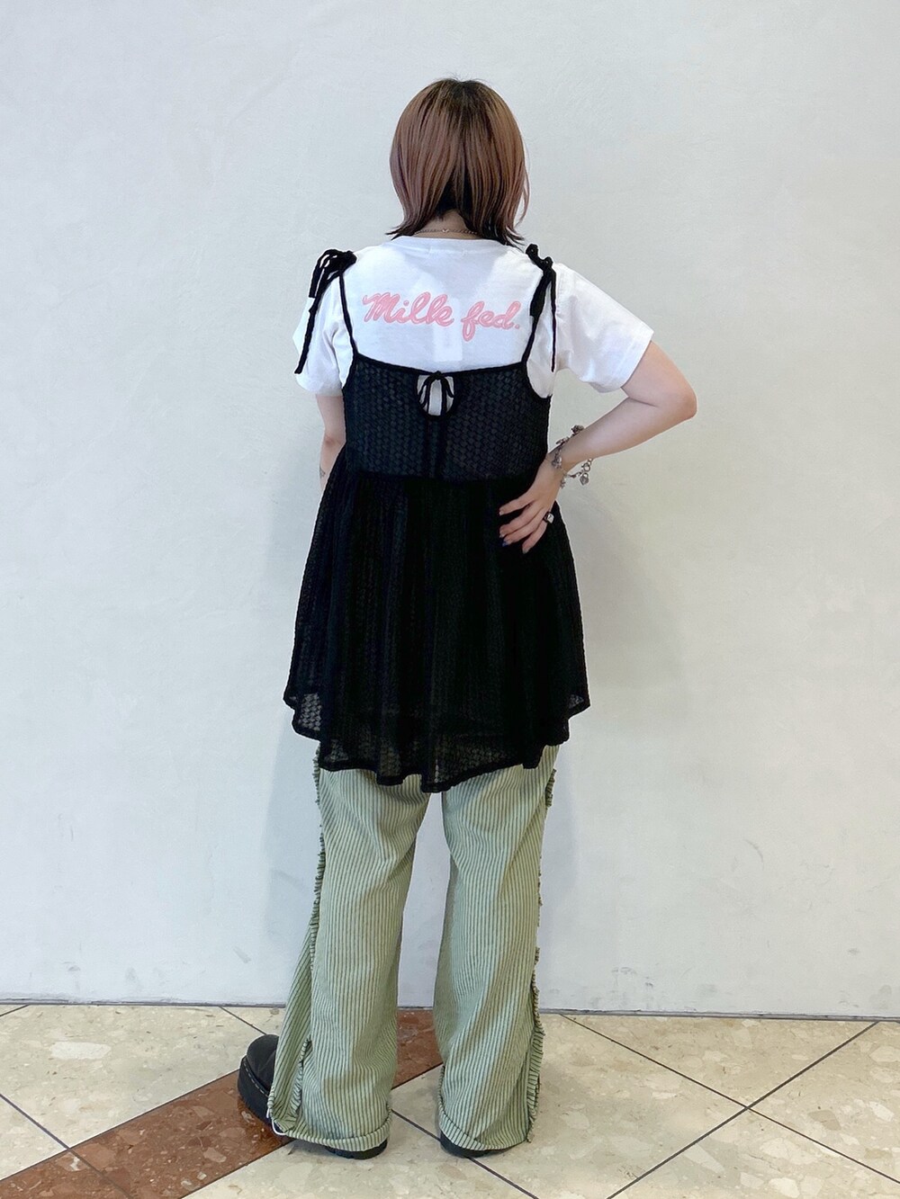 ブラック系のキャミソール、グリーン系のその他パンツ、ブラック系のブーツを着用したレディースの夏コーディネートの3枚目の写真