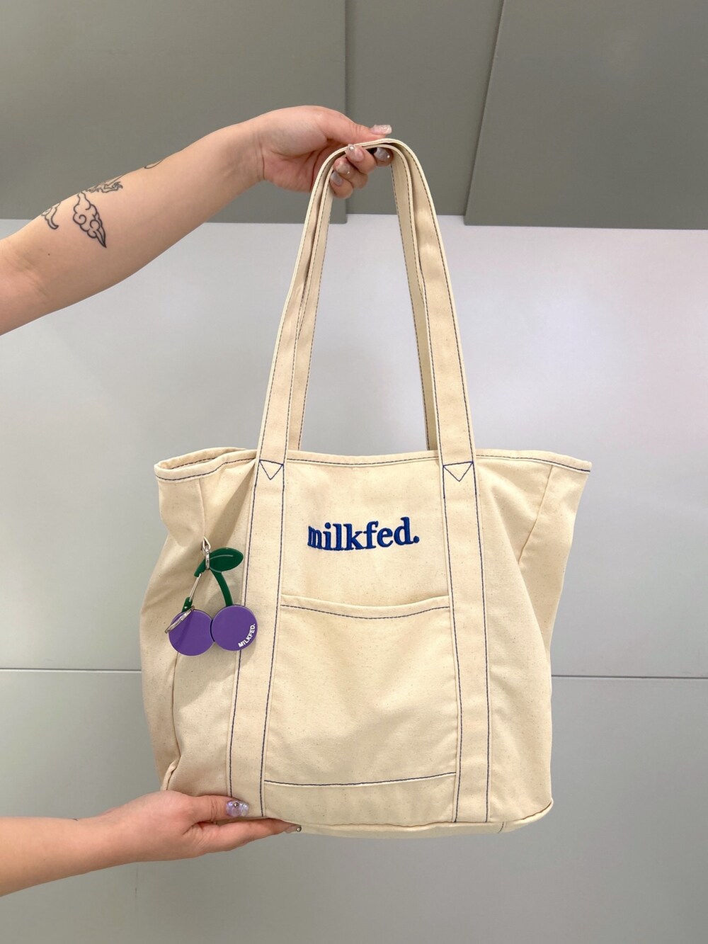 ホワイト系のTシャツ/カットソー、ブラック系のスカート、ブルー系のトートバッグを着用したレディースの春コーディネートの5枚目の写真