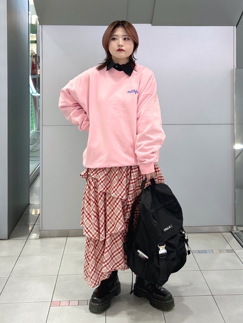 ブラック系のシャツ/ブラウス、レッド系のスカート、ブラック系のバックパック/リュックを着用したレディースの冬コーディネートの2枚目の写真