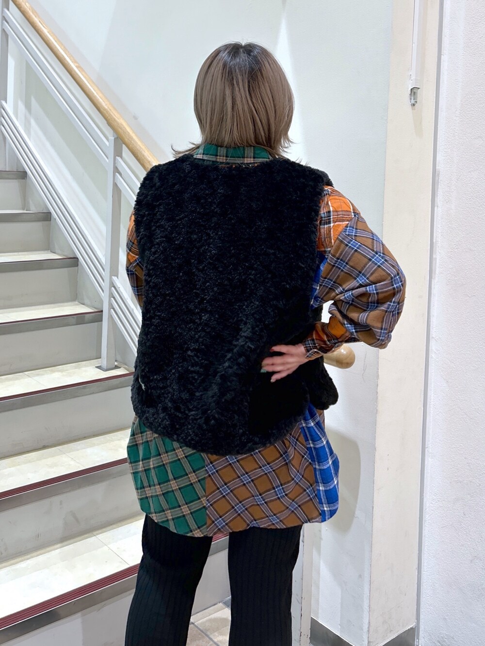 パープル系のショルダーバッグ、ブラック系のベスト、ブラウン系のシャツ/ブラウスを着用したレディースの冬コーディネートの4枚目の写真