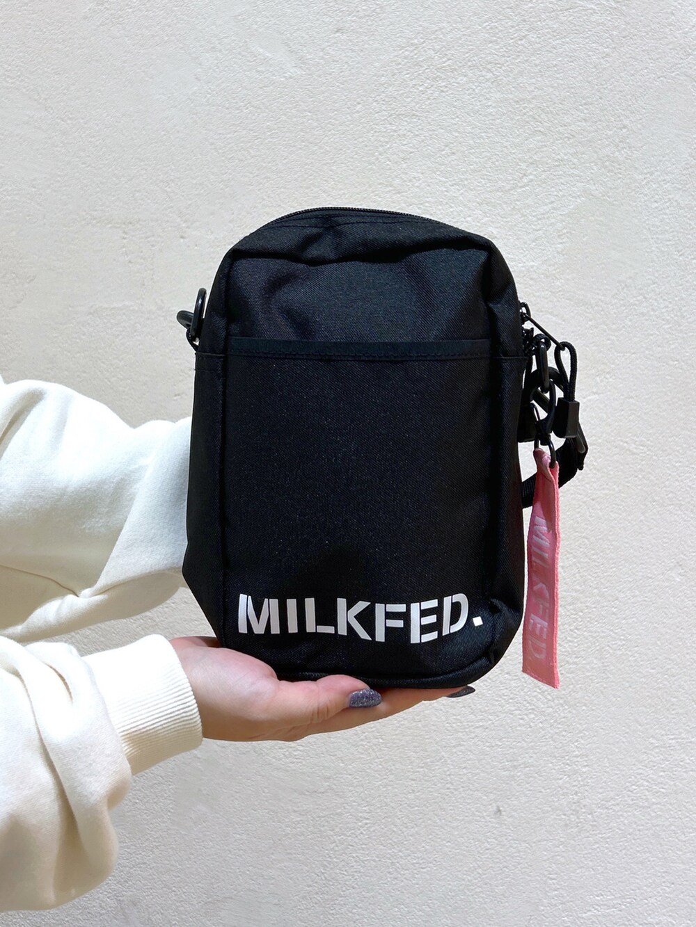 ホワイト系のパーカー、ピンク系のショルダーバッグ、グレー系のワンピースを着用したレディースの秋コーディネートの5枚目の写真