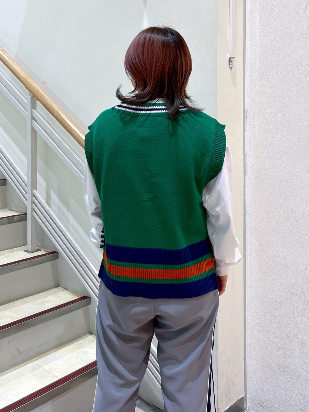 ホワイト系のTシャツ/カットソー、グリーン系のベスト、グレー系のその他パンツを着用したレディースの冬コーディネートの7枚目の写真