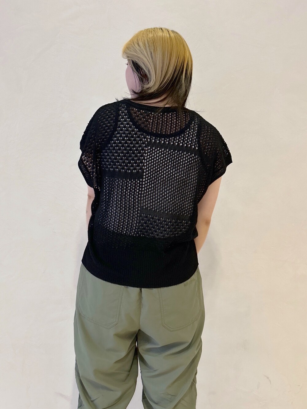 グリーン系のその他パンツ、ブラック系のTシャツ/カットソー、ホワイト系のタンクトップを着用したレディースの春コーディネートの4枚目の写真