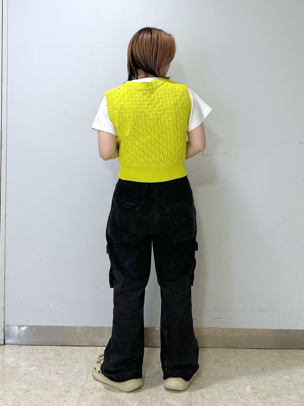ホワイト系のTシャツ/カットソー、イエロー系のベスト、ブラック系のカーゴパンツを着用したレディースの夏コーディネートの4枚目の写真