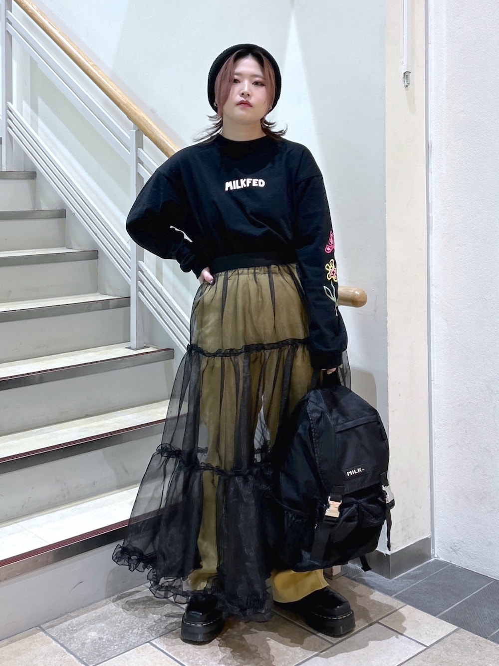 ブラック系のTシャツ/カットソー、ブラック系のバックパック/リュック、ブラック系のブーツを着用したレディースの冬コーディネートの3枚目の写真