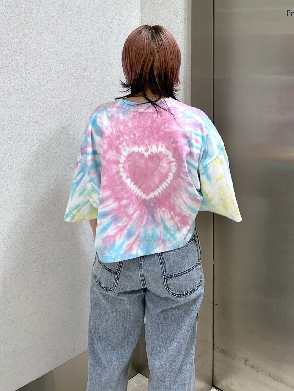 ブルー系のデニムパンツ、ブラック系のショルダーバッグ、ベージュ系のサンダルを着用したレディースの夏コーディネートの5枚目の写真