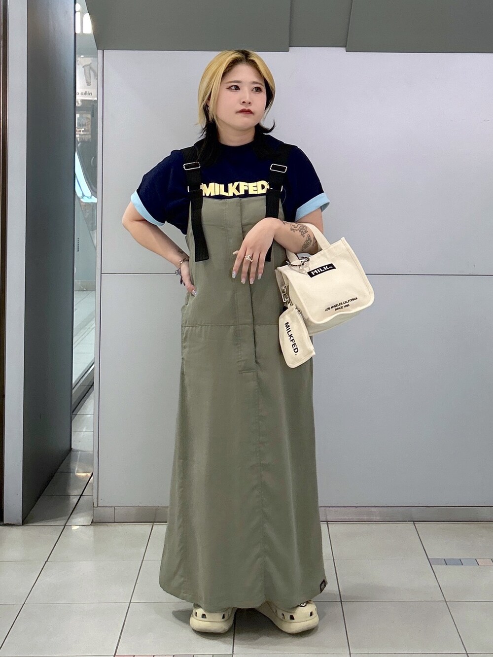 ブルー系のTシャツ/カットソー、グリーン系のワンピース、ホワイト系のショルダーバッグを着用したレディースの春コーディネートの2枚目の写真