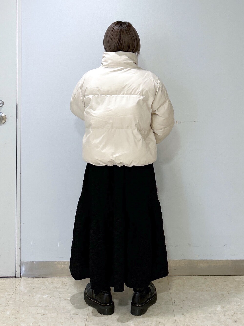 ホワイト系のダウンジャケット/コート、ブラック系のワンピース、パープル系のショルダーバッグを着用したレディースの冬コーディネートの3枚目の写真