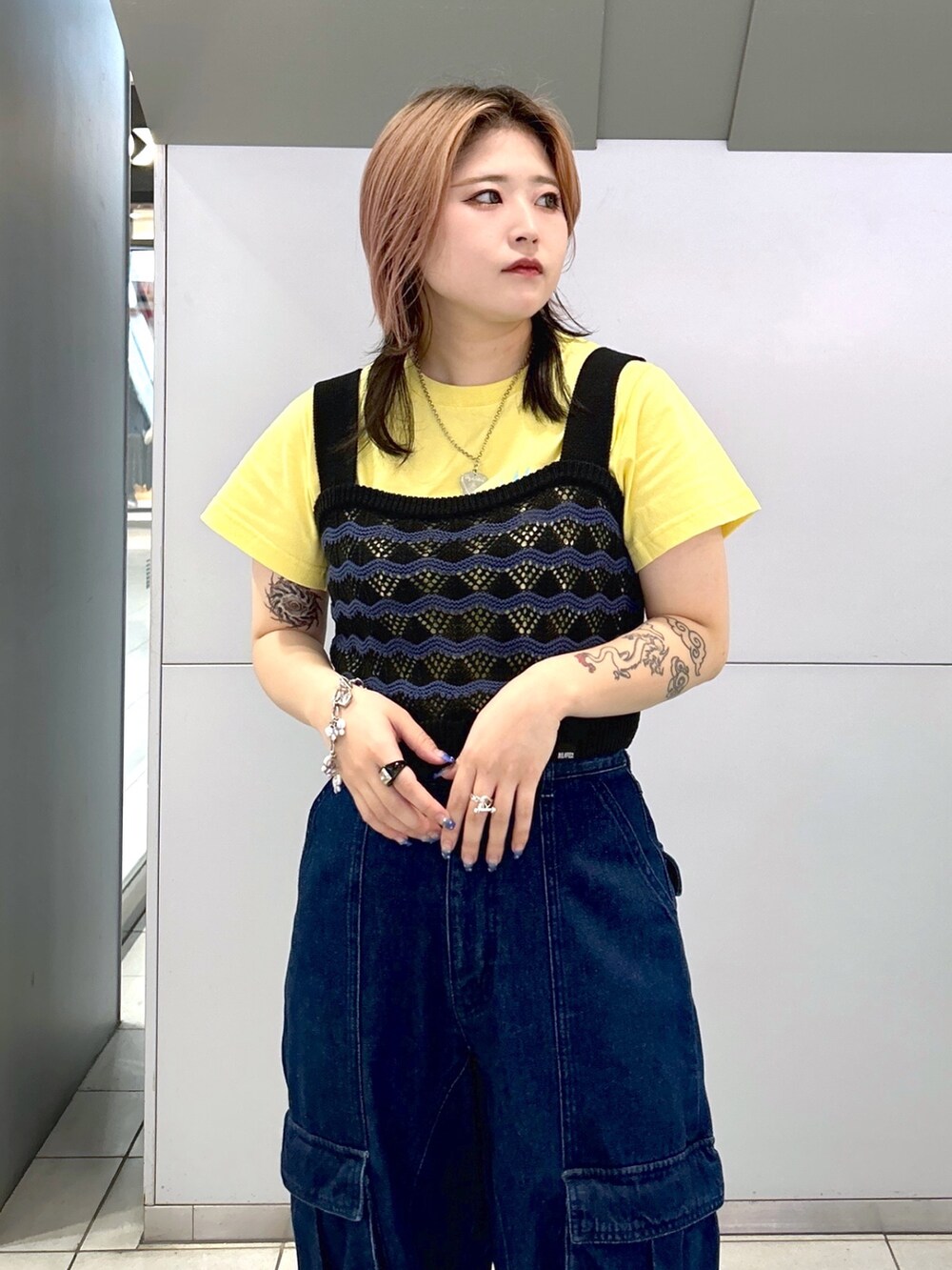 イエロー系のTシャツ/カットソー、ブラック系のキャミソール、ブラック系のブーツを着用したレディースの夏コーディネートの5枚目の写真